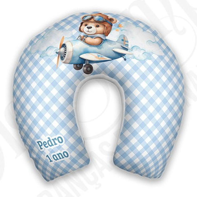 Almofada de pescoço infantil Urso Aviador: urso pilotando avião sobre fundo xadrez azul e branco.