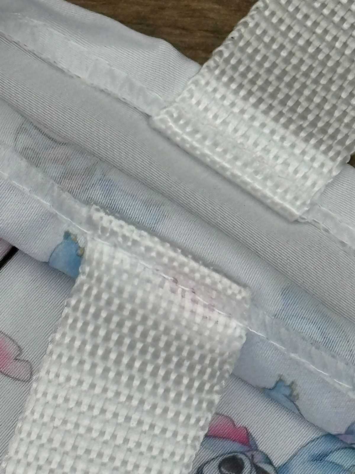 Detalhe de costura e alça branca em ecobag de referência com estampa Stitch.
