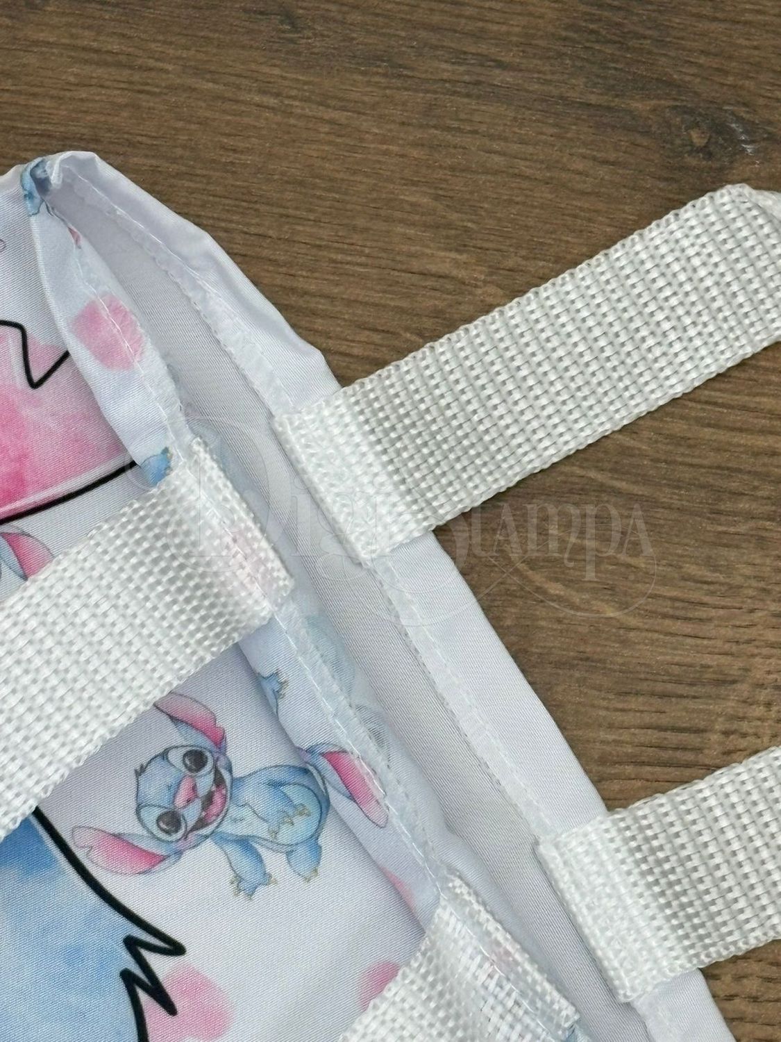 Detalhe de costura e alça branca em ecobag de referência com estampa Stitch.