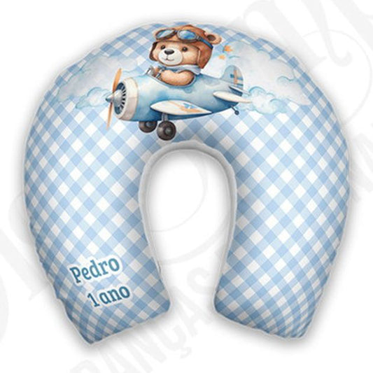 Almofada de pescoço infantil Urso Aviador: urso pilotando avião sobre fundo xadrez azul e branco.